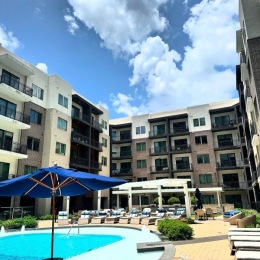 Our pool is weekend ready! ? pool in front of a building with a blue umbrella