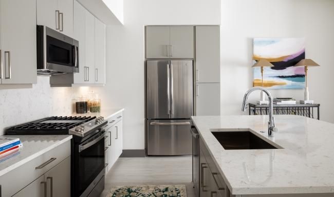 Spacious kitchens with thoughtful details a kitchen with grey cabinets and stainless steel appliances