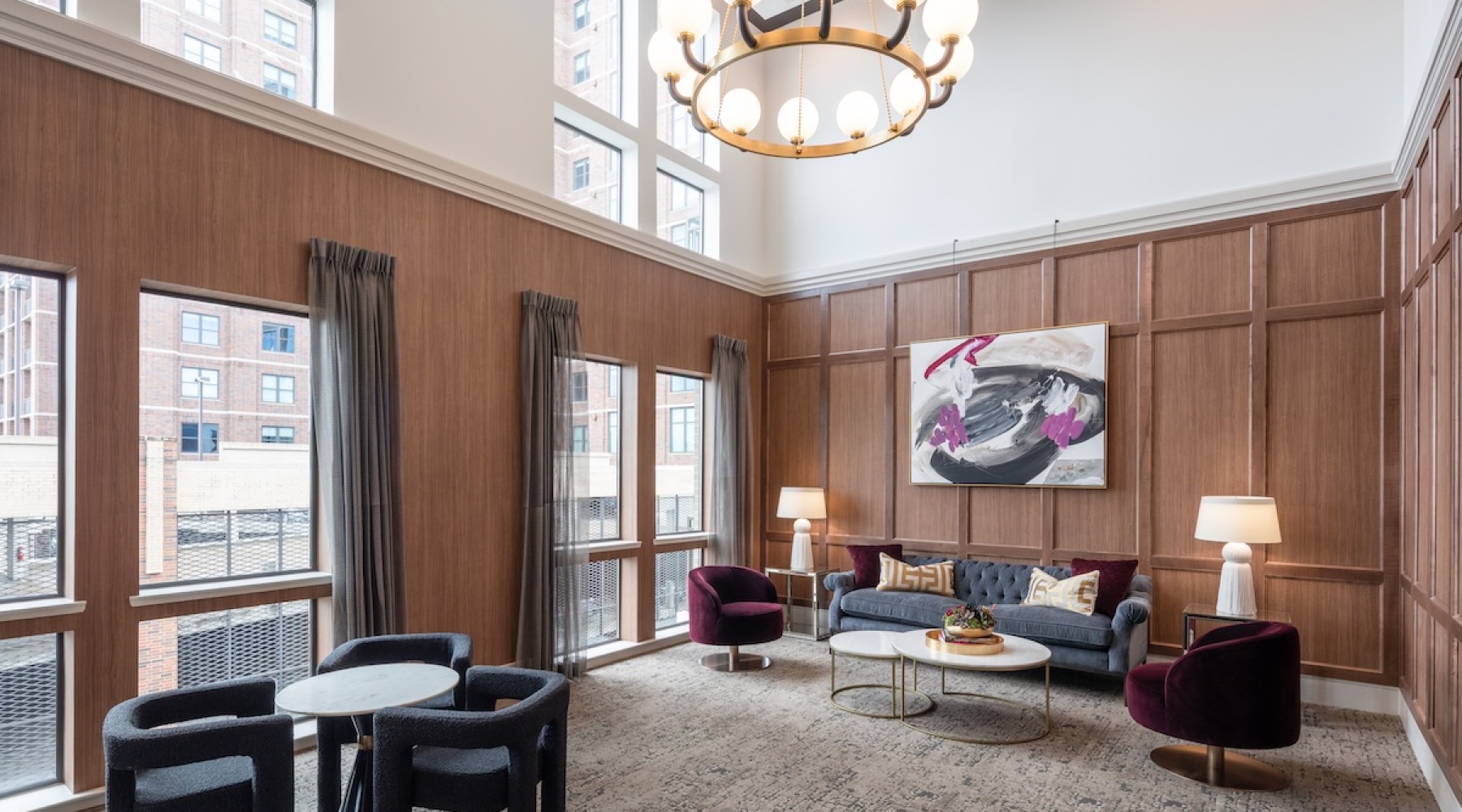 Take advantage of all Chelsea Museum District has to offer lounge area with black chairs a couch and chandelier with big windows