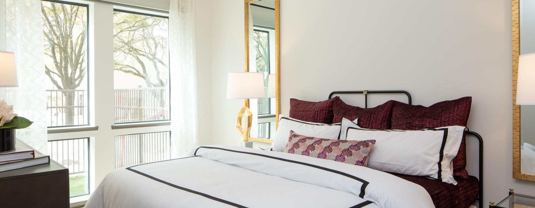 a bed with red and white pillows